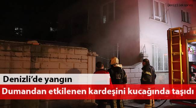 Dumandan etkilenen kardeşini kucağında taşıdı