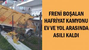 Freni boşalan hafriyat kamyonu ev ve yol arasında asılı kaldı