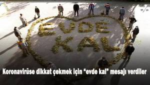 Temizlik işçileri ağaçlardan dökülen yapraklarla “Evde Kal” mesajı verdi